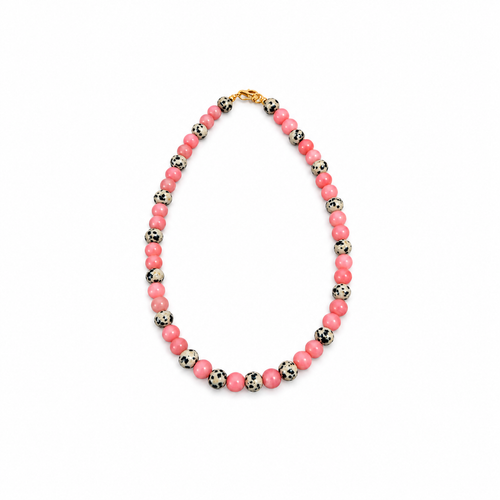 A beaded necklace featuring alternating pink and black-and-white spotted beads, completed with a gold clasp, shown on a plain white background.
